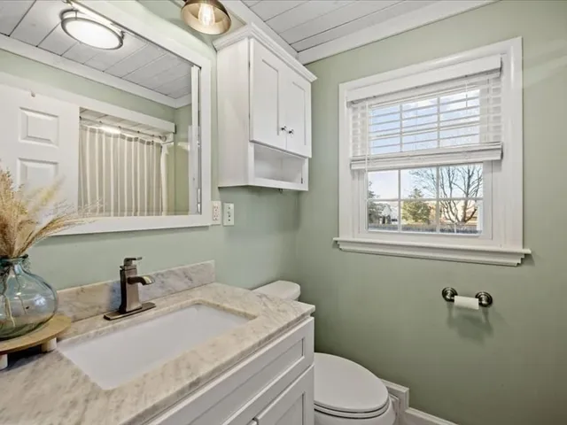 a bathroom with a sink vanity mirror and toilet