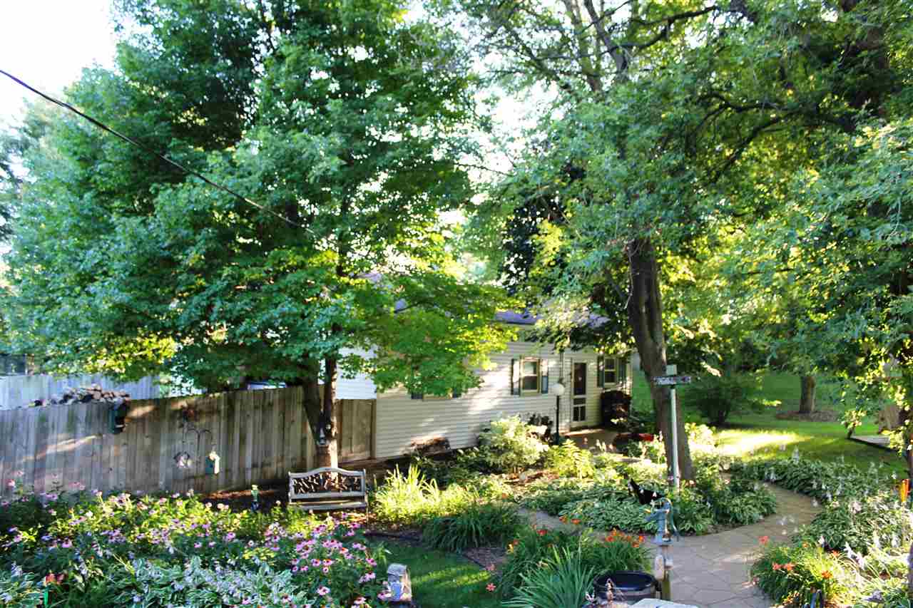 6056 North Knoll Road Monroe Center, IL 61052 - Photo 20 of 24 a backyard of a house with lots of green space and fountain in front of it