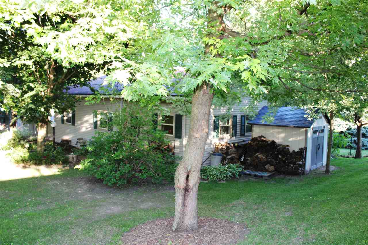 6056 North Knoll Road Monroe Center, IL 61052 - Photo 21 of 24 a backyard of a house with table and chairs plants and large tree