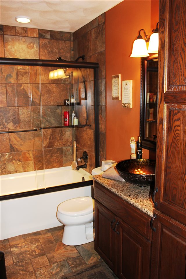 6056 North Knoll Road Monroe Center, IL 61052 - Photo 6 of 24 a bathroom with a granite countertop sink a toilet a mirror and bathtub