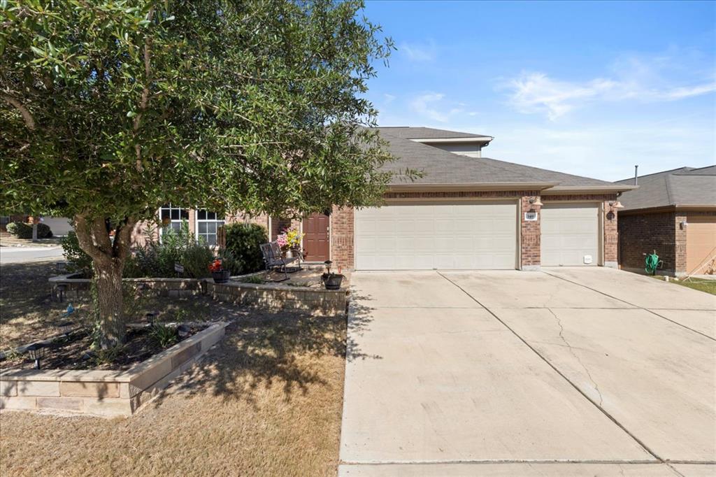 349 Razzmatazz Trail Buda, TX 78610 - Photo 3 of 27 Brick facade with a welcoming front entrance and multi-car driveway.