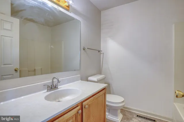 a bathroom with a sink a toilet and vanity