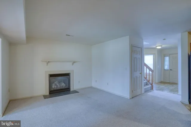 an empty room with a fireplace and window