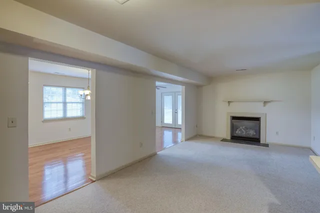 an empty room with a kitchen and fireplace