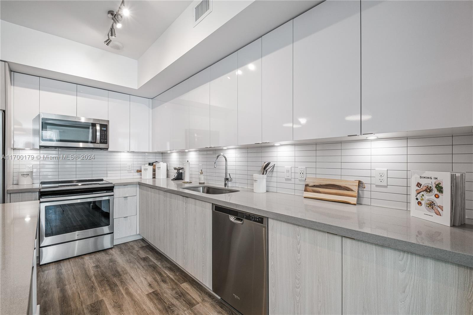 1919 Southeast 10th Avenue, Unit 2130 Fort Lauderdale, FL 33316 - Photo 25 of 35 a kitchen with stainless steel appliances granite countertop a sink a stove a microwave and wooden cabinets