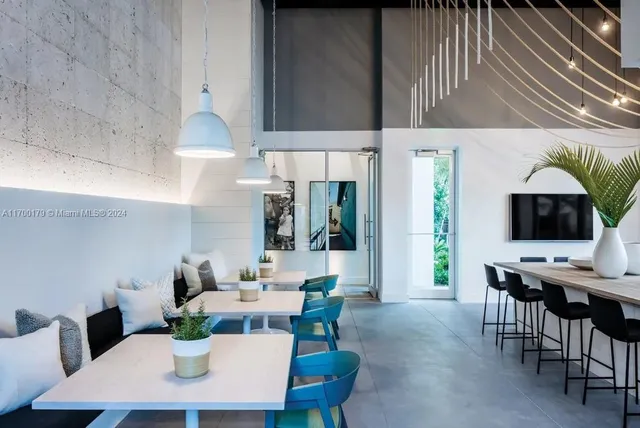 a room with lots of tables a large window and chairs