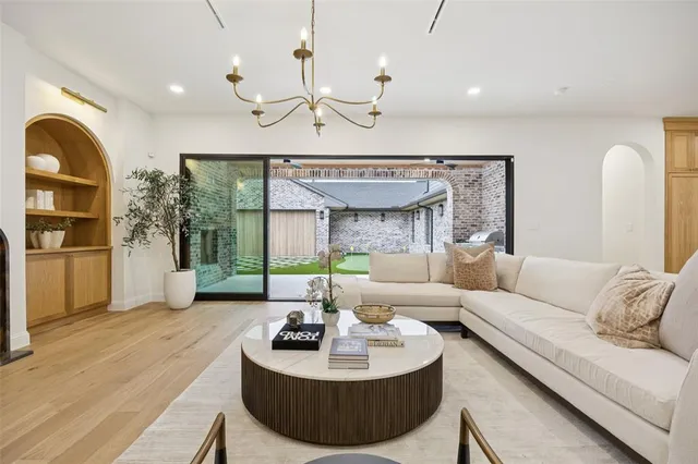 a living room with furniture a fireplace and a chandelier
