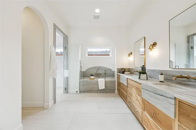 a large bathroom with a double vanity sink a mirror and a bathtub