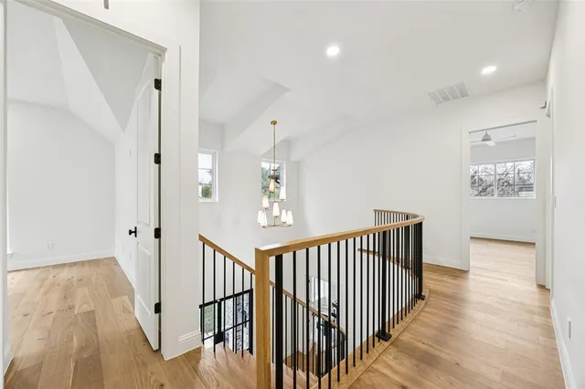 a view of a hallway with wooden floor and staircase