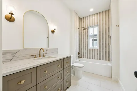 a spacious bathroom with a granite countertop sink toilet and shower
