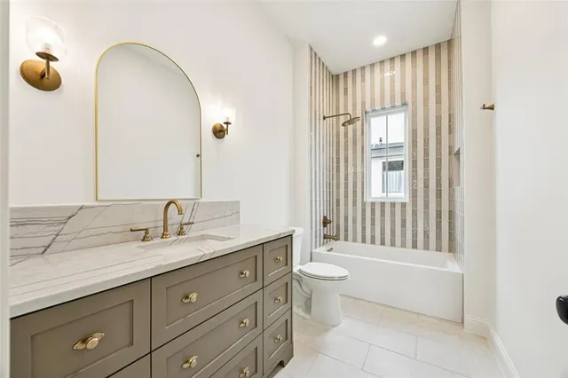 a spacious bathroom with a granite countertop sink toilet and shower