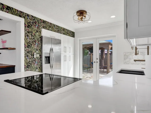 a kitchen with stainless steel appliances granite countertop a refrigerator and a stove top oven