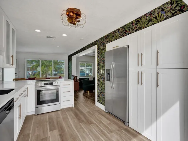 a kitchen with stainless steel appliances kitchen island granite countertop a sink and cabinets