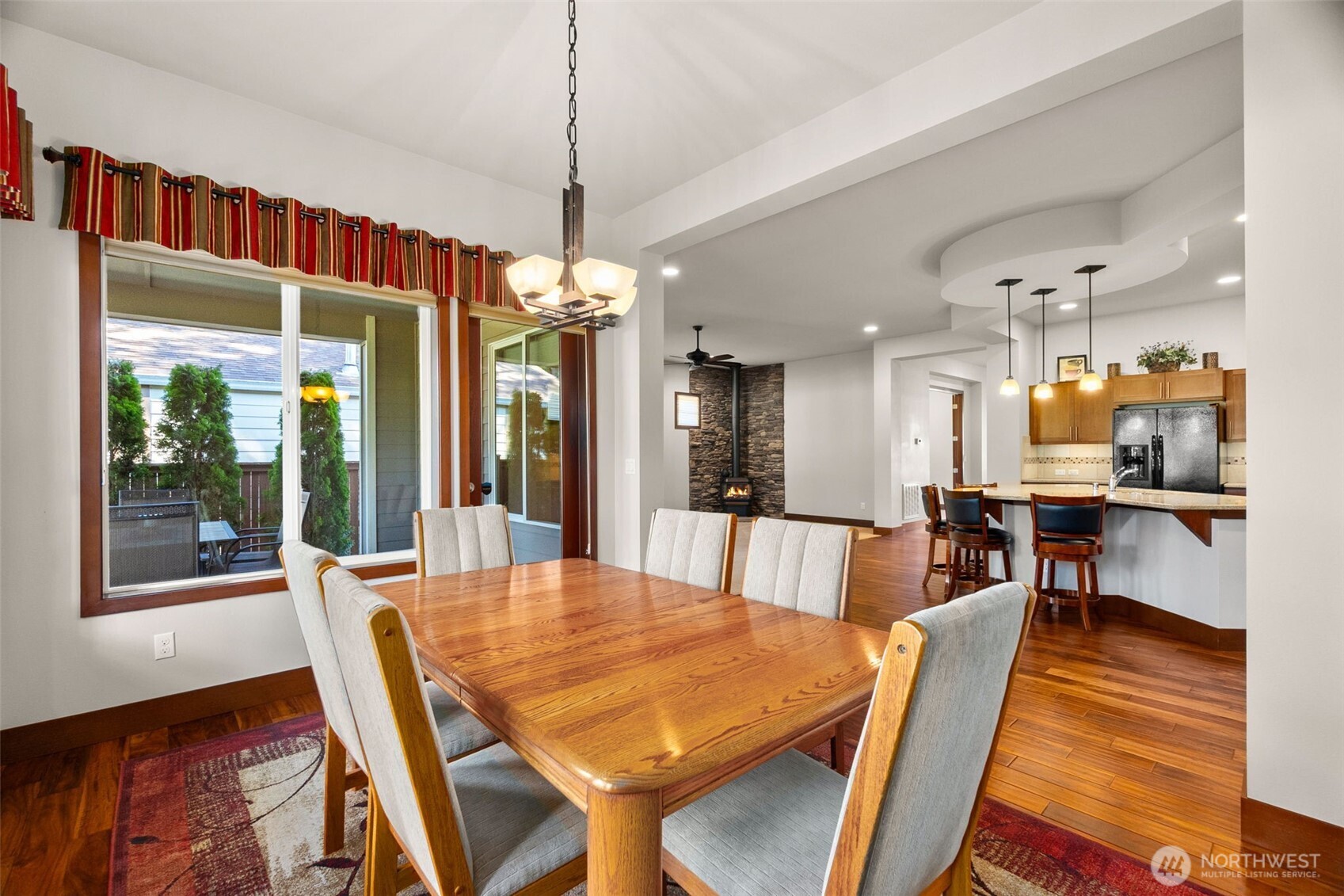 8235 Orcas Loop Northeast Olympia, WA 98516 - Photo 17 of 39 a dining room with wooden floor a chandelier a wooden table and chairs