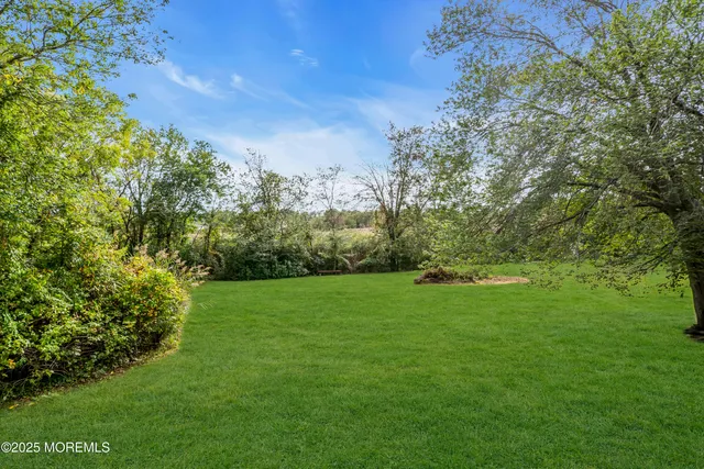 a view of a house with a yard balcony and a tree