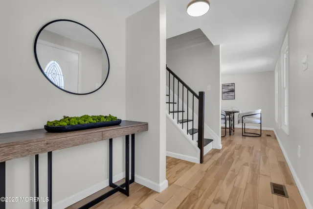 a living room with furniture a chandelier a mirror and a potted plant