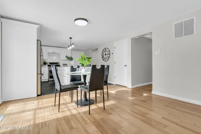 a view of a kitchen with wooden floor and electronic appliances