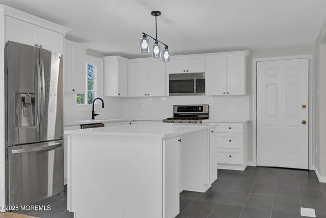 a kitchen with stainless steel appliances a stove refrigerator sink and microwave