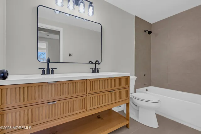 a bathroom with a double vanity sink mirror and toilet