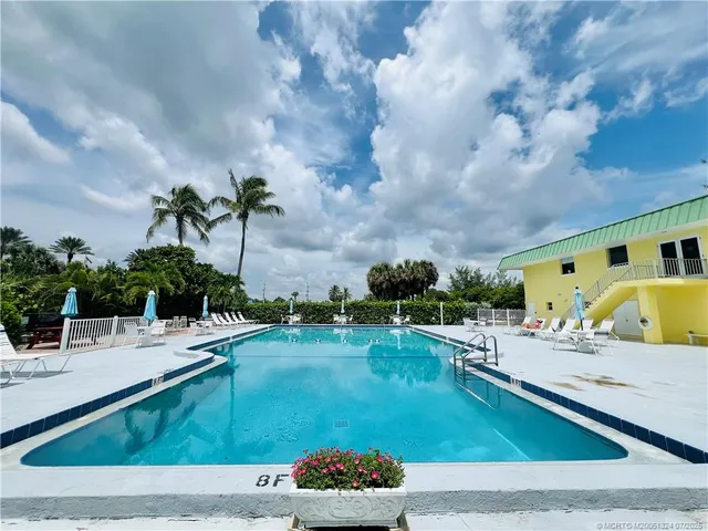 a view of swimming pool with outdoor seating and plants