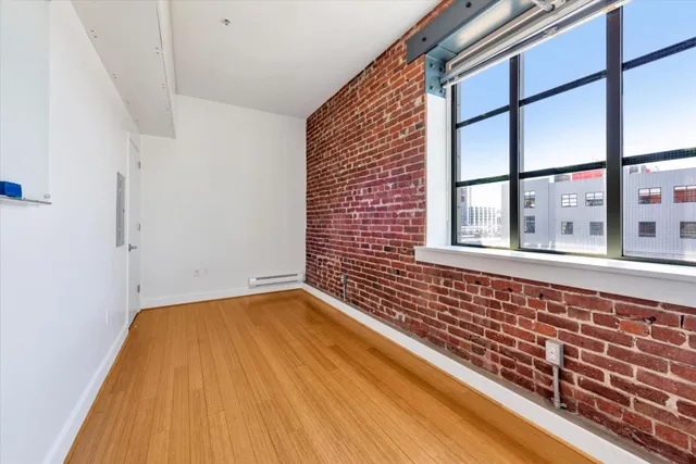 a view of a room with wooden floor and windows