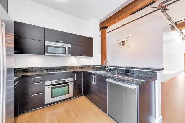 a kitchen with stainless steel appliances granite countertop a stove and a microwave
