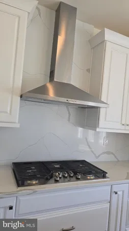 a kitchen with white cabinets and a stove