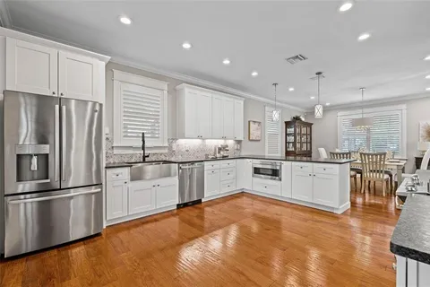 a kitchen with granite countertop a refrigerator sink and cabinets