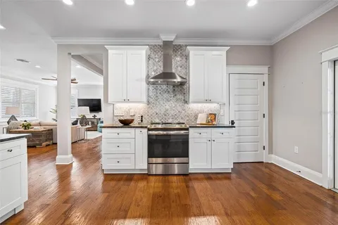 a kitchen with granite countertop a stove and a wooden floors