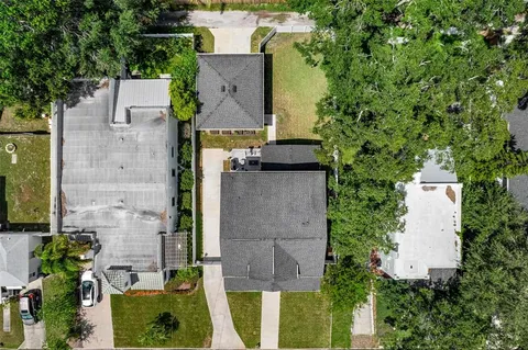 a front view of a house with a yard and potted plants