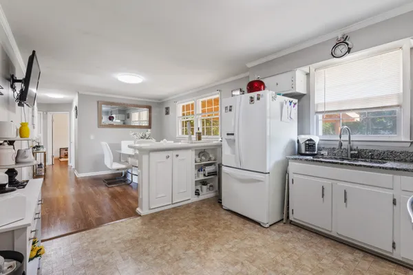 a white kitchen with cabinets and a refrigerator