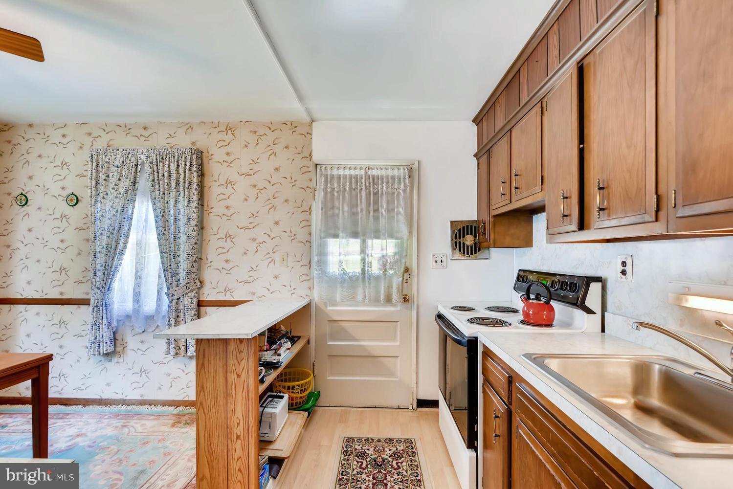 1018 St Albans Road Baltimore, MD 21239 - Photo 14 of 28 a kitchen with a sink stove and cabinets