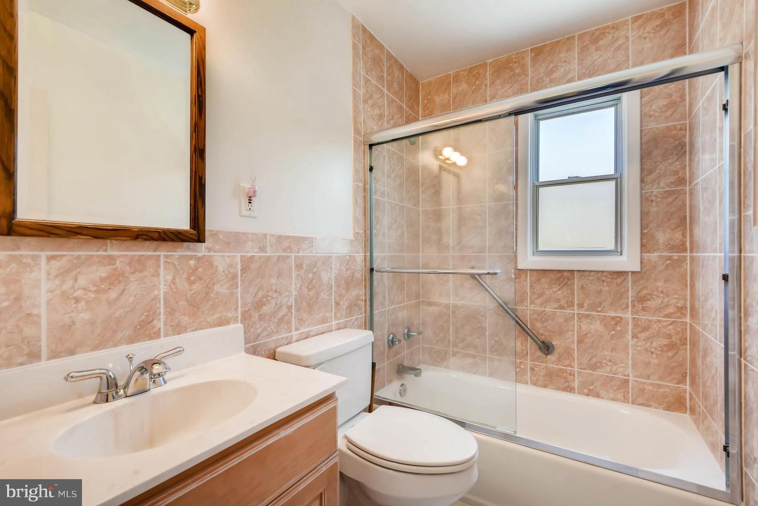1018 St Albans Road Baltimore, MD 21239 - Photo 18 of 28 a bathroom with a bathtub shower sink vanity and toilet