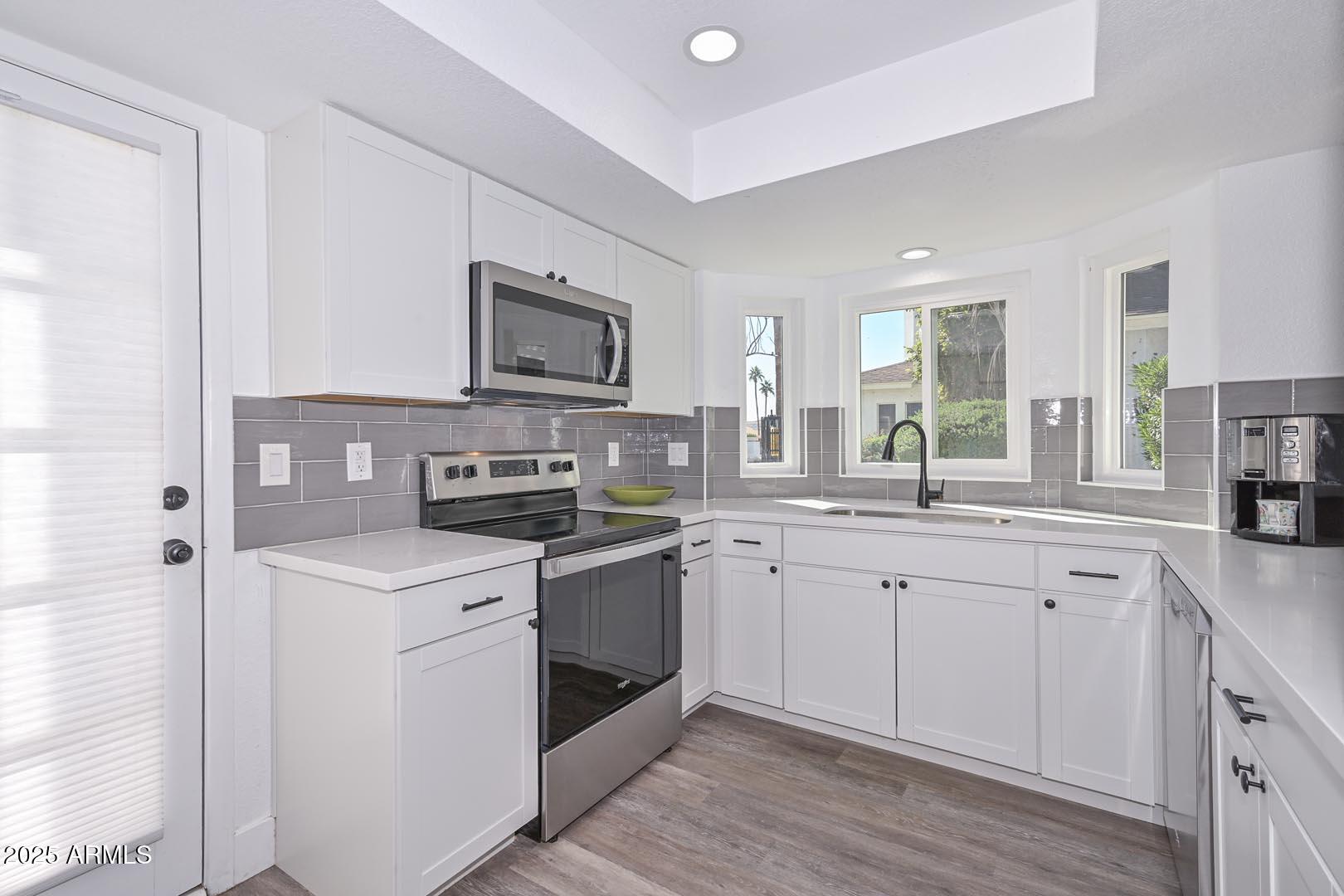 606 West Grandview Road Phoenix, AZ 85023 - Photo 7 of 33 a kitchen with stainless steel appliances granite countertop a stove sink and cabinets