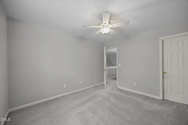 an empty room with closet and fan