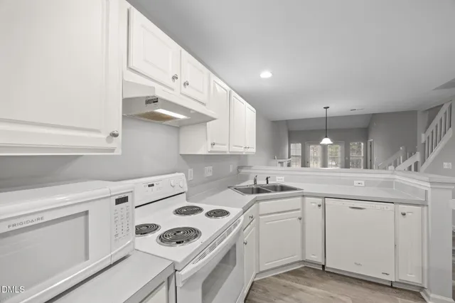 a kitchen with a sink a stove and cabinets