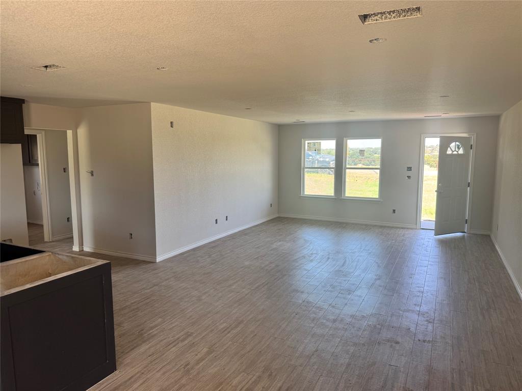 163 Agnes Circle Springtown, TX 76082 - Photo 3 of 7 an empty room with wooden floor and windows