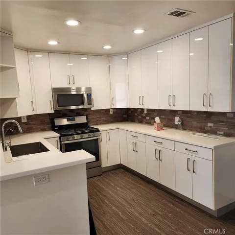 a kitchen with granite countertop white cabinets and black appliances