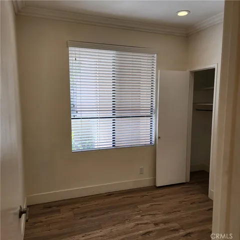 an empty room with wooden floor and a window