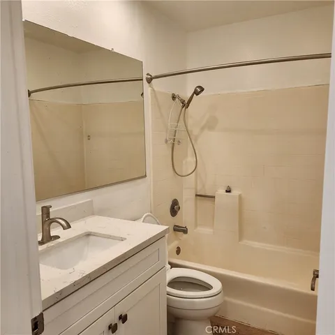a bathroom with a granite countertop sink a toilet and shower