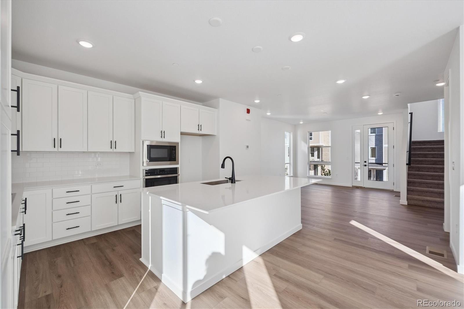 1227 Rhett Drive Erie, CO 80026 - Photo 12 of 24 a large kitchen with stainless steel appliances lots of counter space and wooden floor