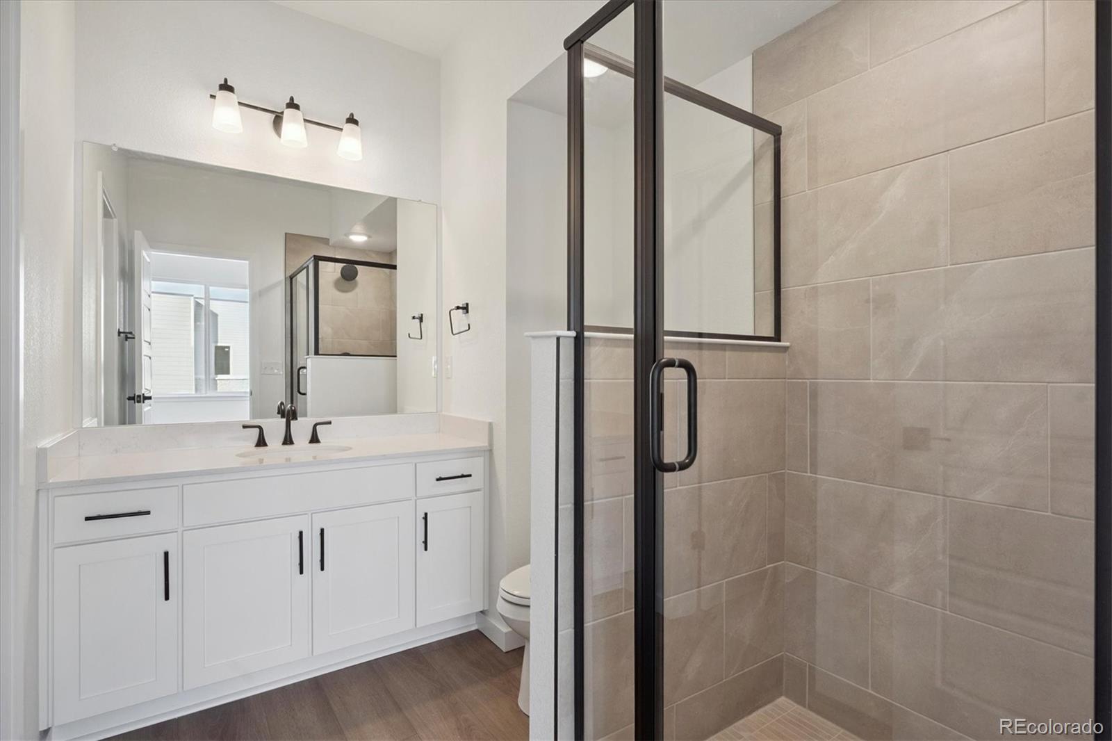 1227 Rhett Drive Erie, CO 80026 - Photo 15 of 24 a bathroom with a double vanity sink mirror and shower
