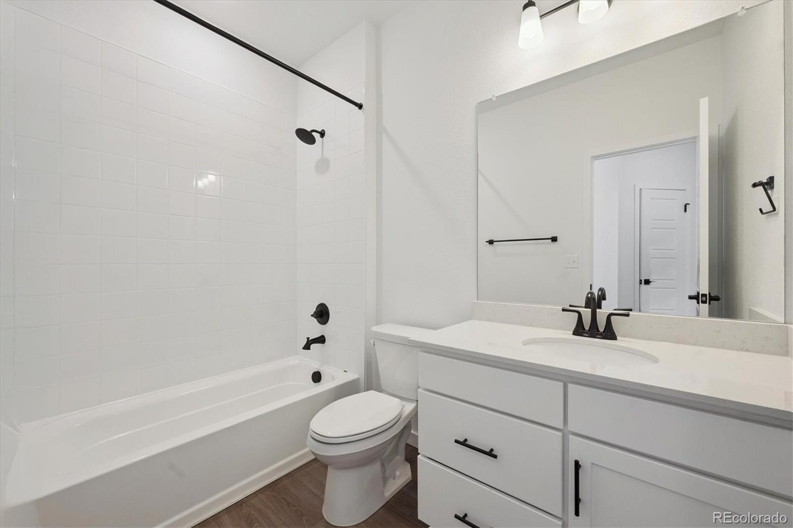 1227 Rhett Drive Erie, CO 80026 - Photo 17 of 24 a bathroom with a bathtub shower sink vanity mirror and toilet