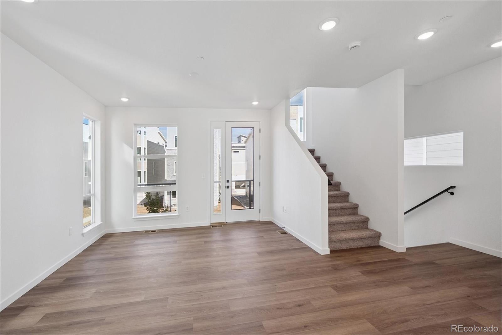 1227 Rhett Drive Erie, CO 80026 - Photo 5 of 24 a view of an empty room with wooden floor and stairs