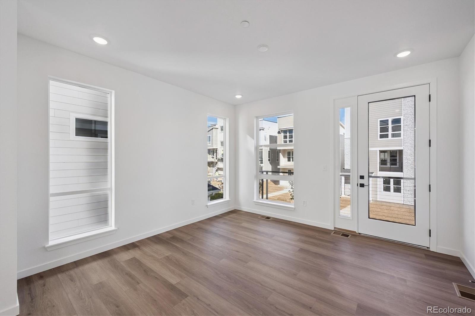 1227 Rhett Drive Erie, CO 80026 - Photo 6 of 24 an empty room with wooden floor and windows
