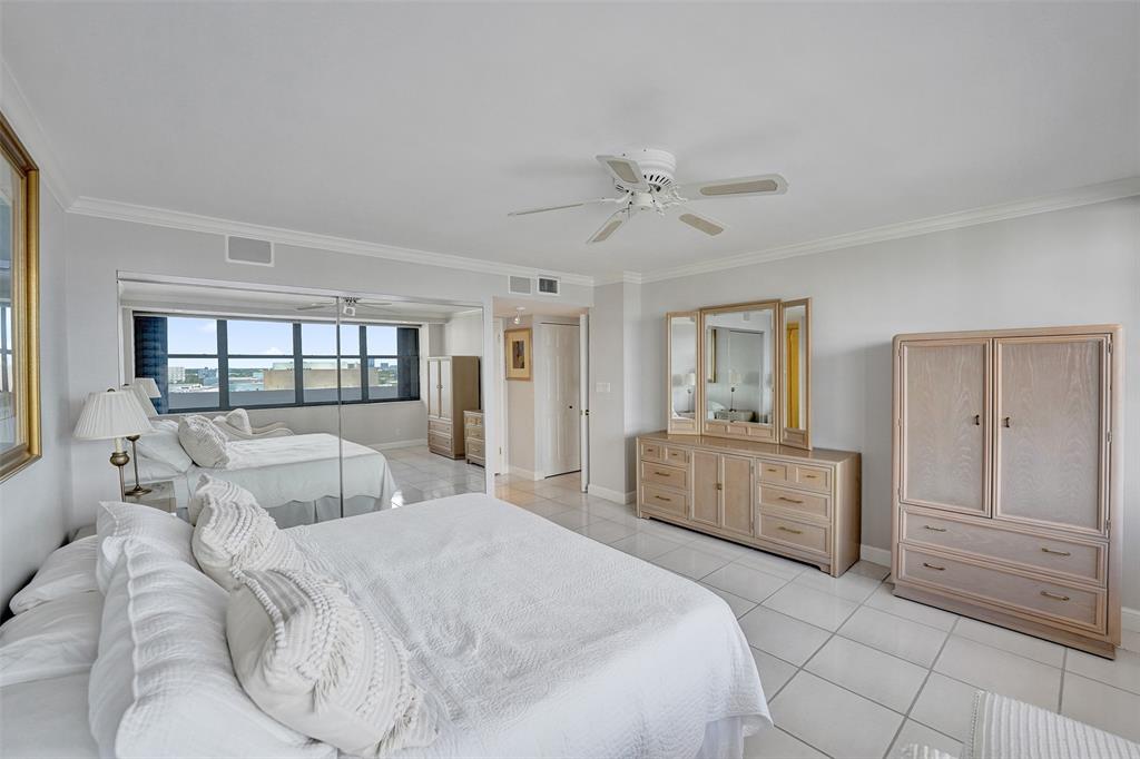 936 Intracoastal Drive, Unit 12C Fort Lauderdale, FL 33304 - Photo 30 of 65 a spacious bedroom with a large bed and a chandelier