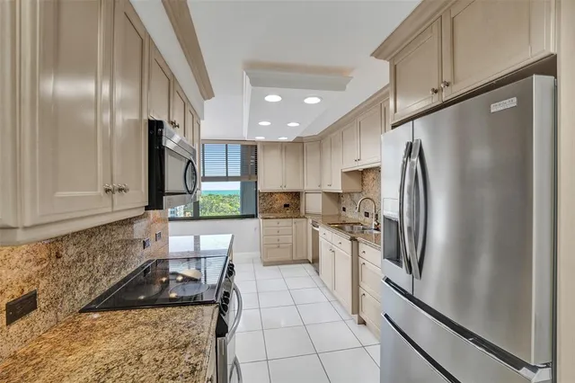 a kitchen with white cabinets a sink and a window