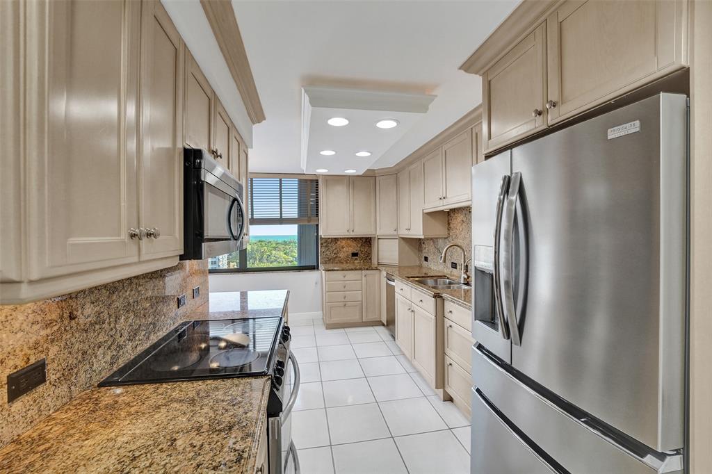 936 Intracoastal Drive, Unit 12C Fort Lauderdale, FL 33304 - Photo 36 of 65 a kitchen with stainless steel appliances granite countertop a refrigerator a sink and white cabinets