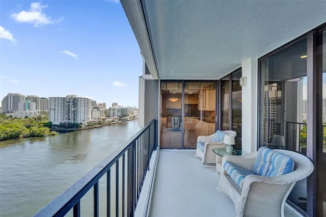 a living room with furniture and floor to ceiling windows