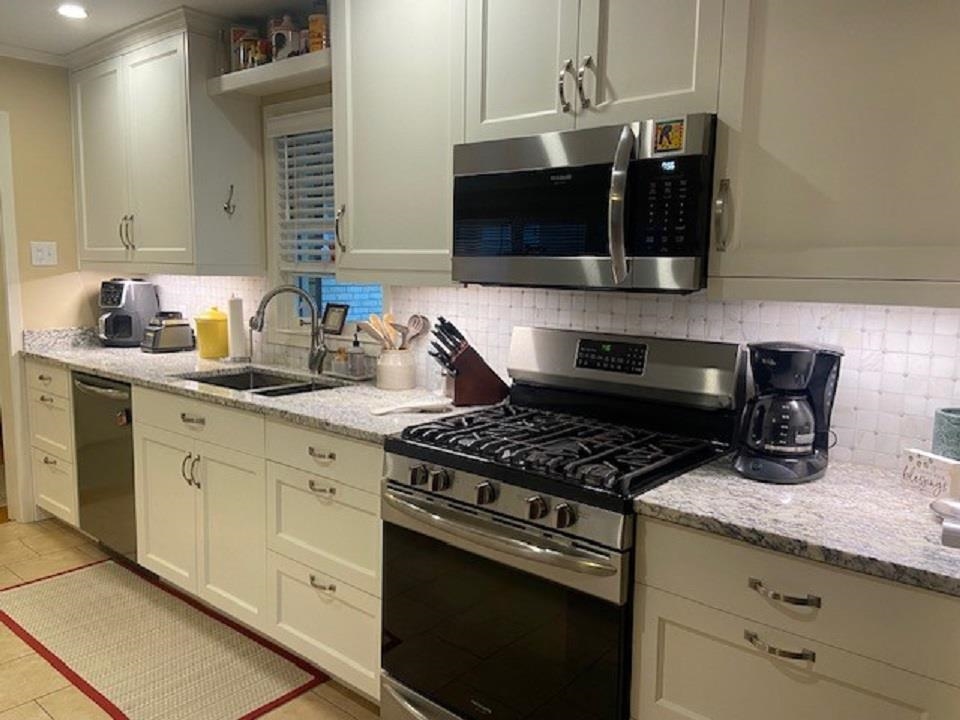 5111 Mason Road Memphis, TN 38117 - Photo 7 of 23 a kitchen with granite countertop stainless steel appliances a sink stove top oven and cabinets